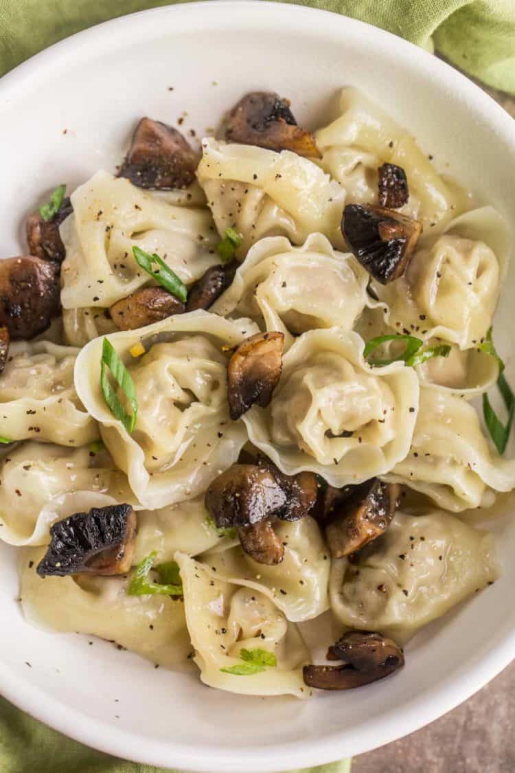 Pelmeni tossed in butter and sauteed mushrooms topped with fresh green onions.