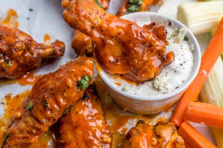 Mild buffalo chicken wings topped with fresh greens dipped into blue cheese ranch with celery.