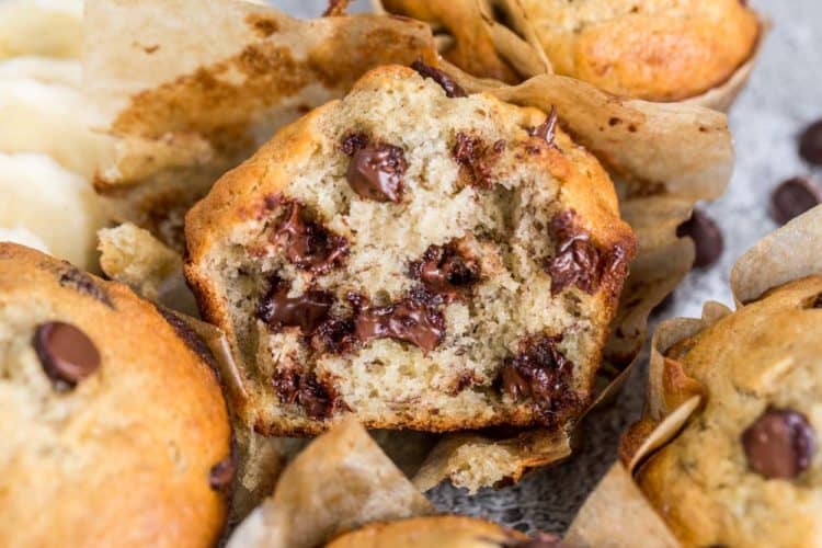 A banana muffin cut in half with melted chocolate chip morsels.