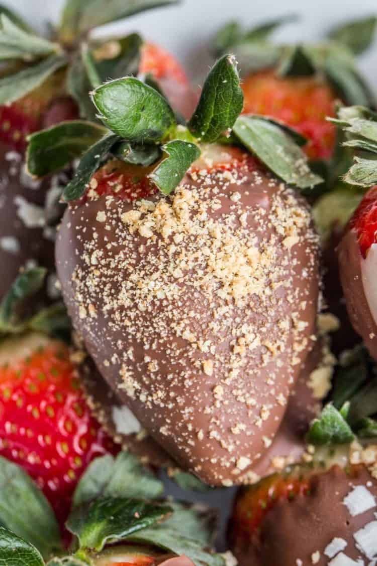 A strawberry dipped in milk chocolate topped with crushed graham crackers. 