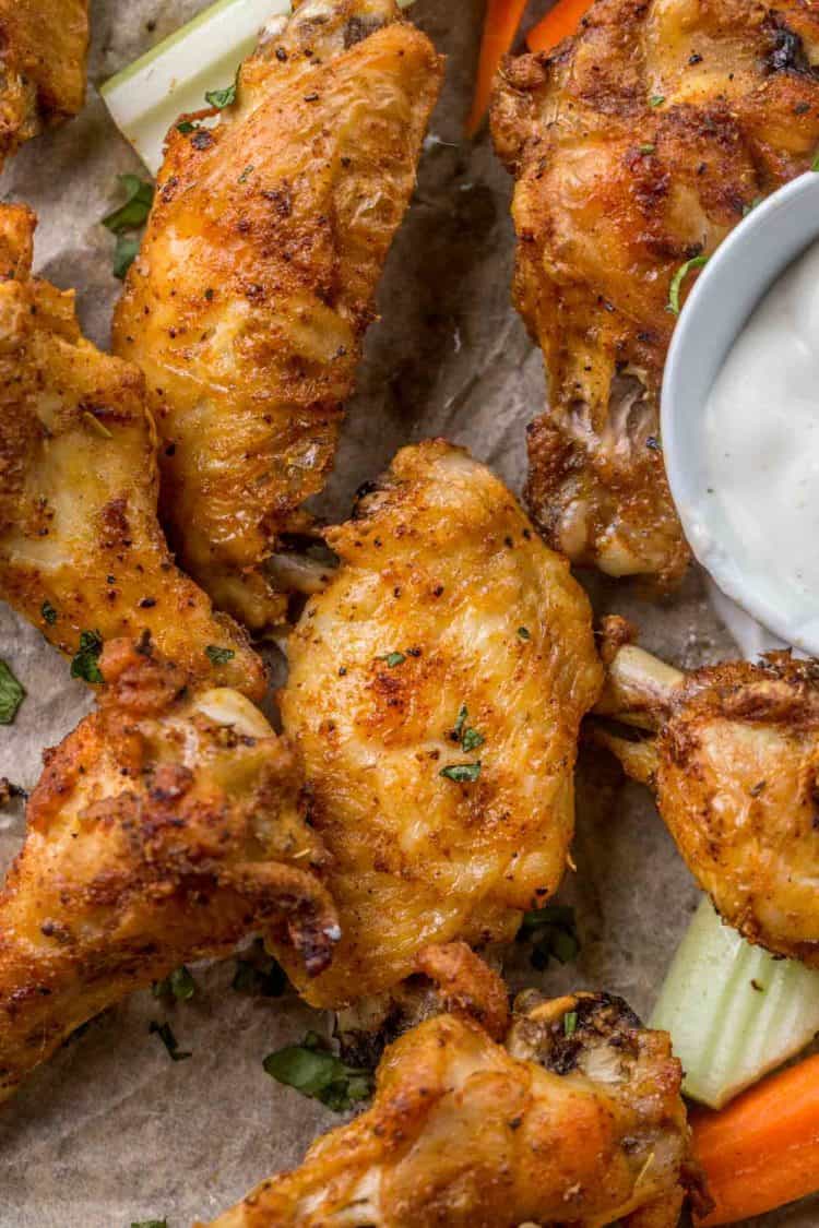 Baked chicken wings on a plate with Ranch and celery.
