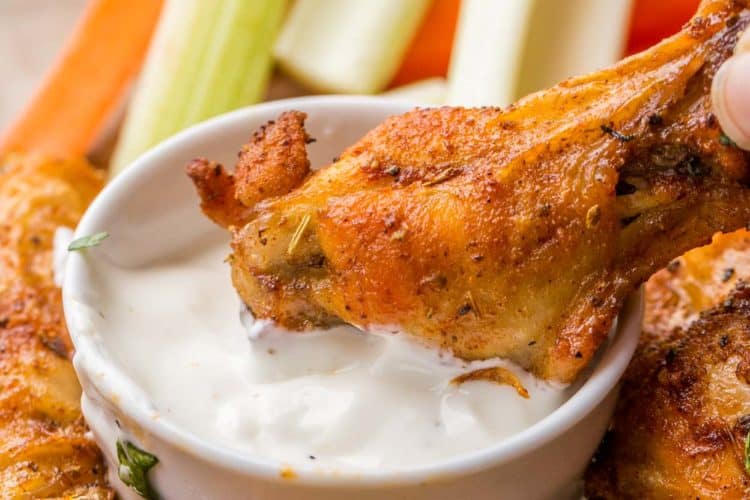 Chicken wings in a plate with ranch dipping sauce.