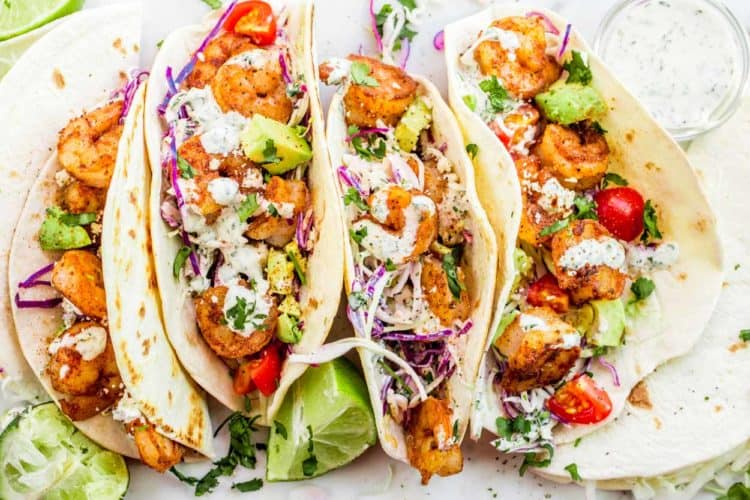 Easy shrimp tacos made with shrimp and loaded with slaw, tomatoes and avocado.
