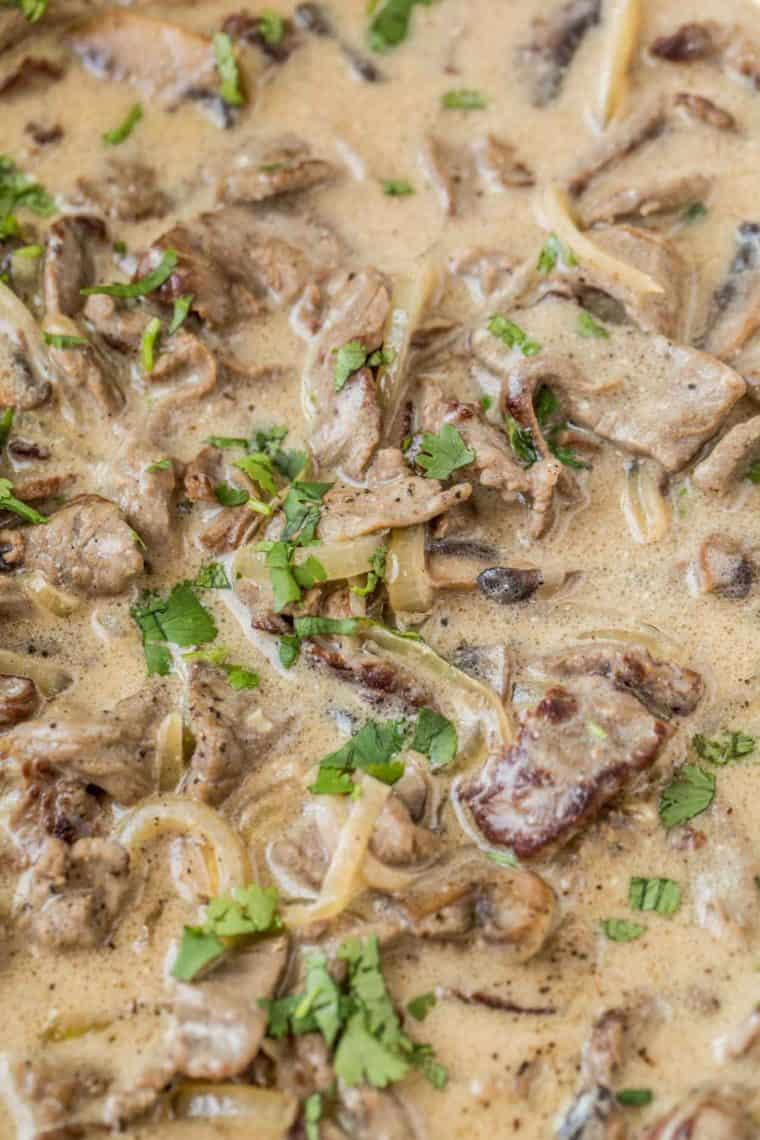 Beef slices, onions, and mushrooms in a creamy gravy topped with fresh greens. 