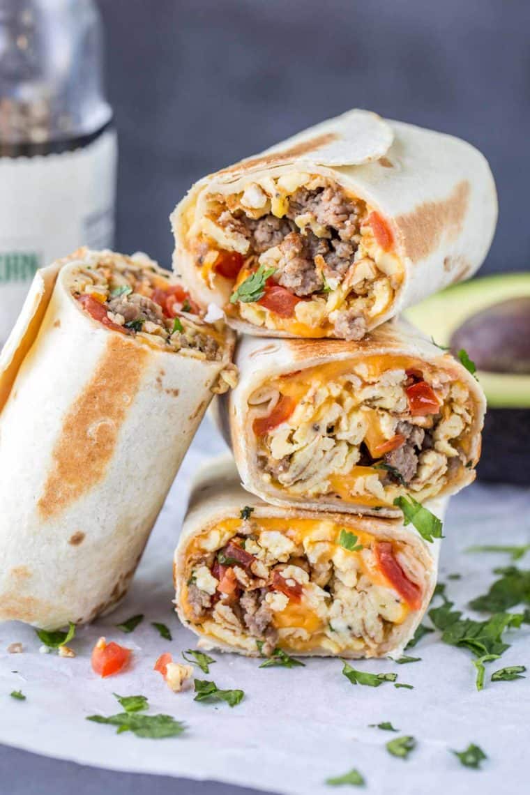 Breakfast burrito stacked on top of each other topped with fresh greens.