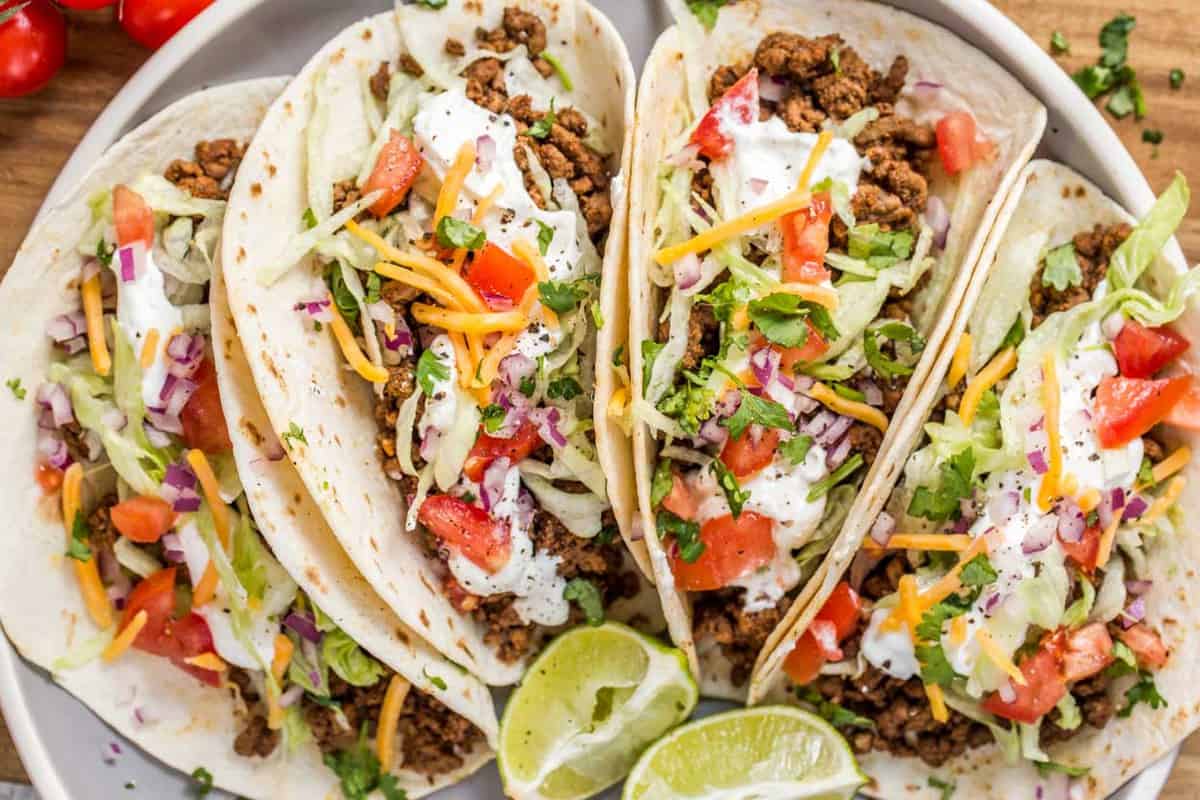 Flour tortillas loaded with ground beef meat and taco toppings. 