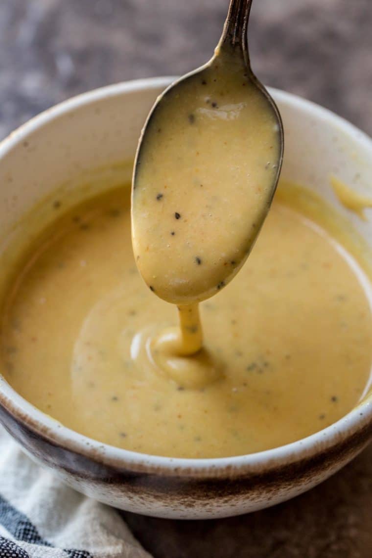 Homemade chick fil a sauce in a white bowl with a spoon of sauce.