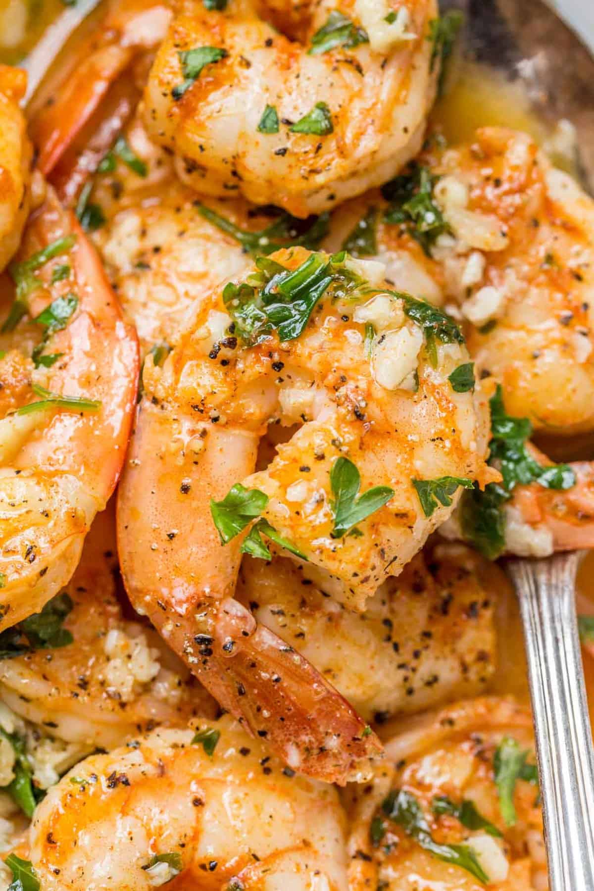 Shrimp scampi topped with black pepper and chopped parsley.