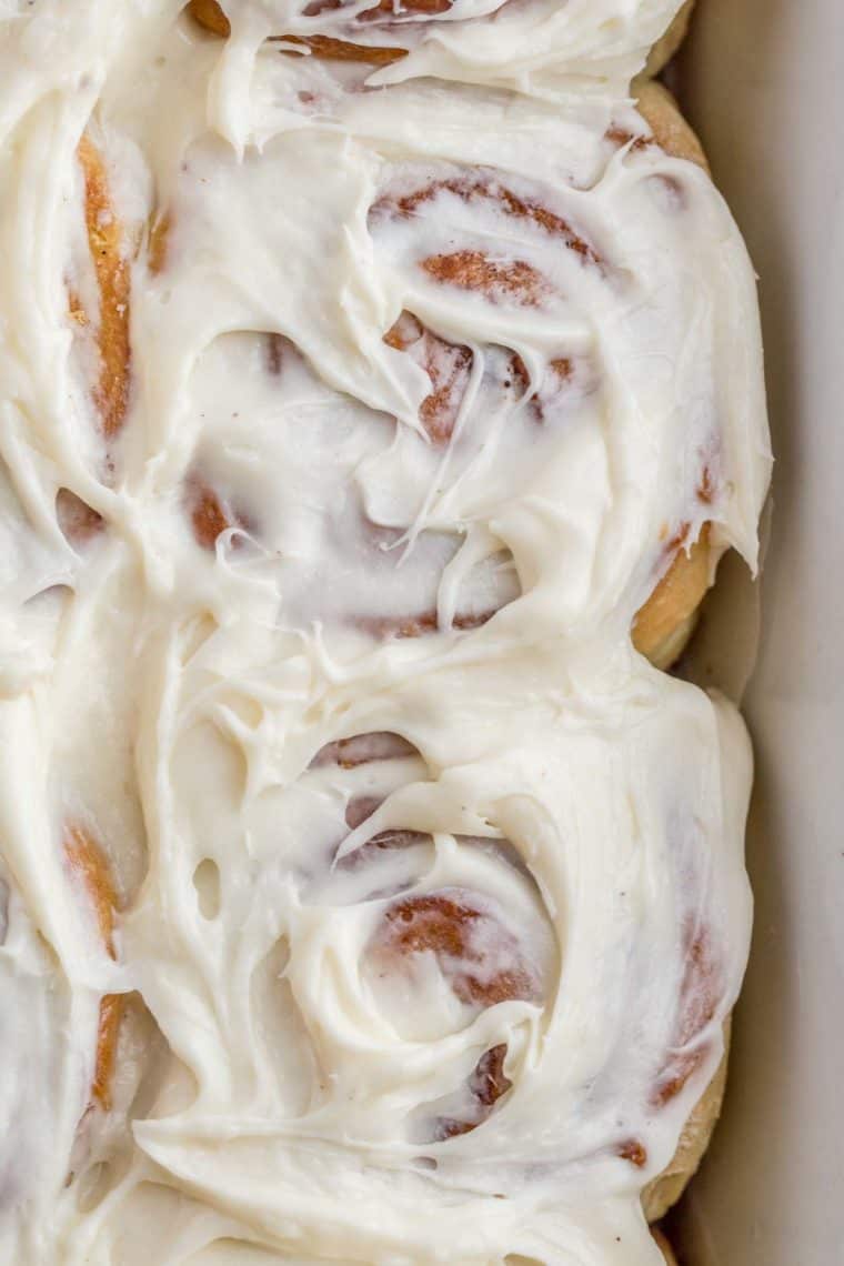 Two sweet cinnamon rolls topped with a creamy cream cheese frosting.