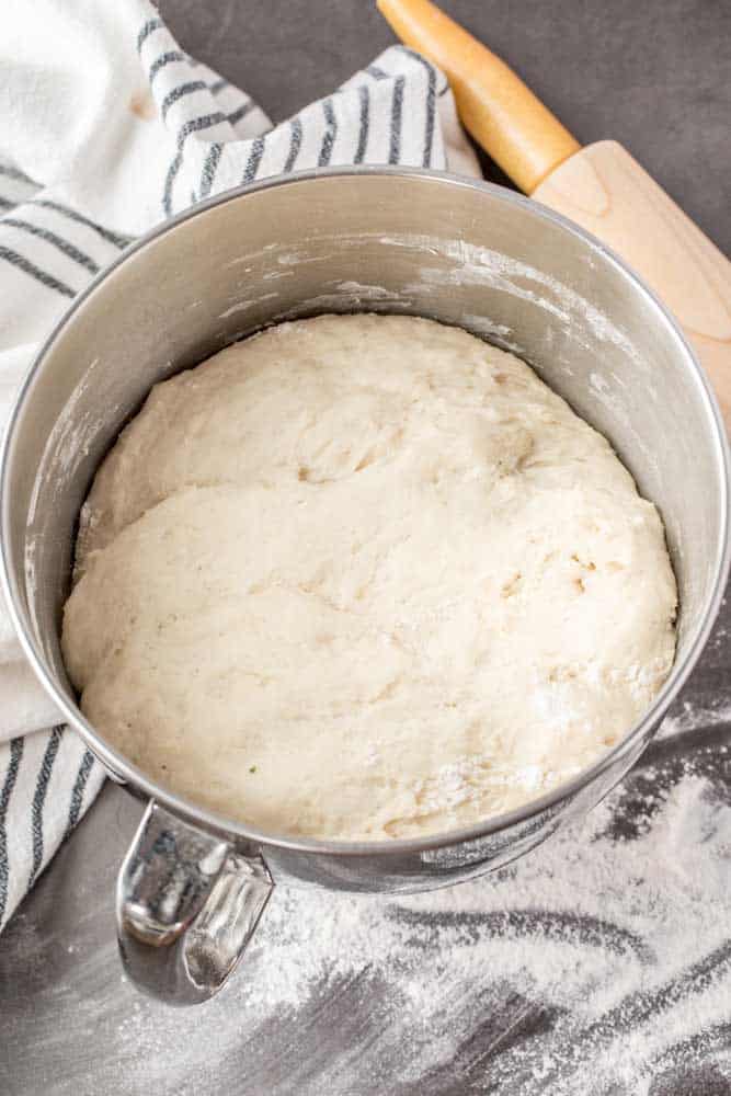 A stainless steel bowl with the risen piroshki dough.