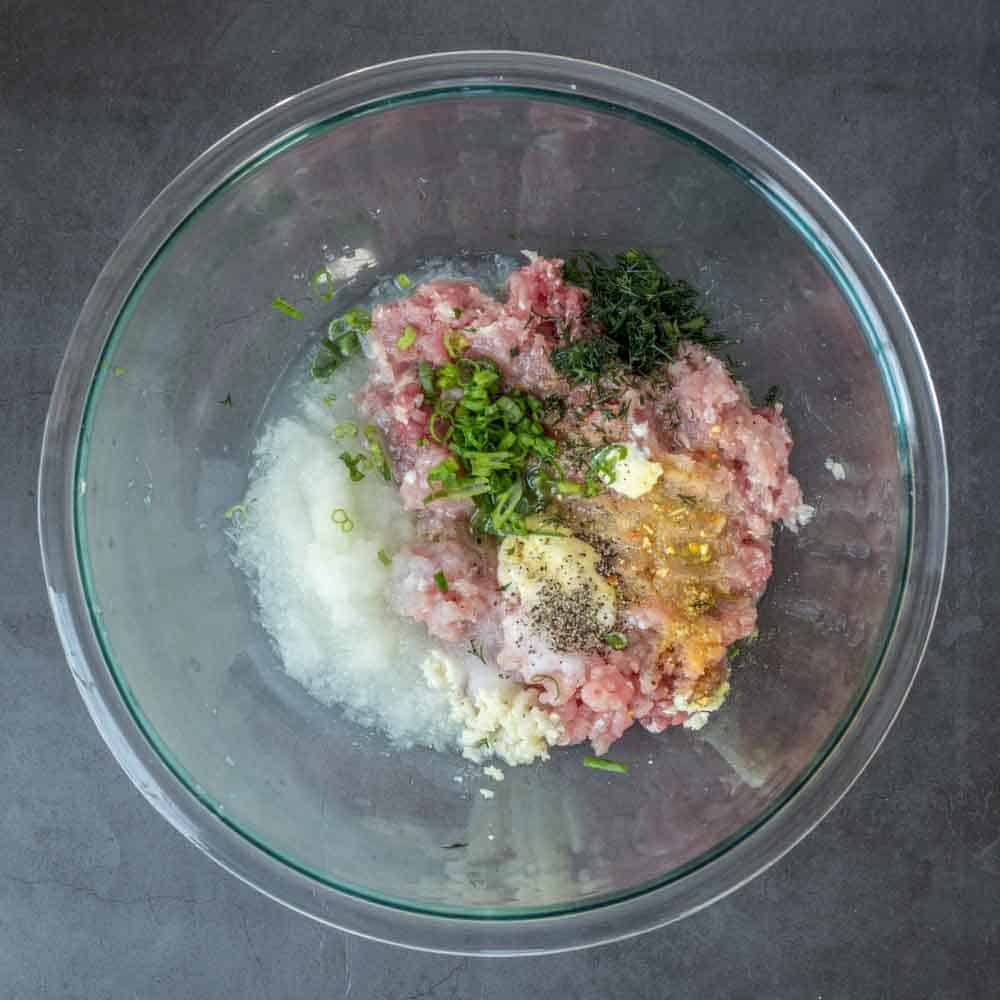 A glass bowl with the piroshki filling ingredients.
