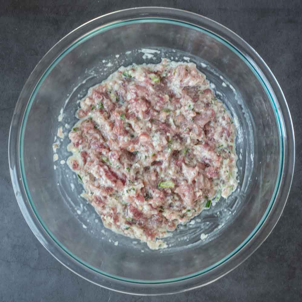 A glass bowl with the mixed meat filling.