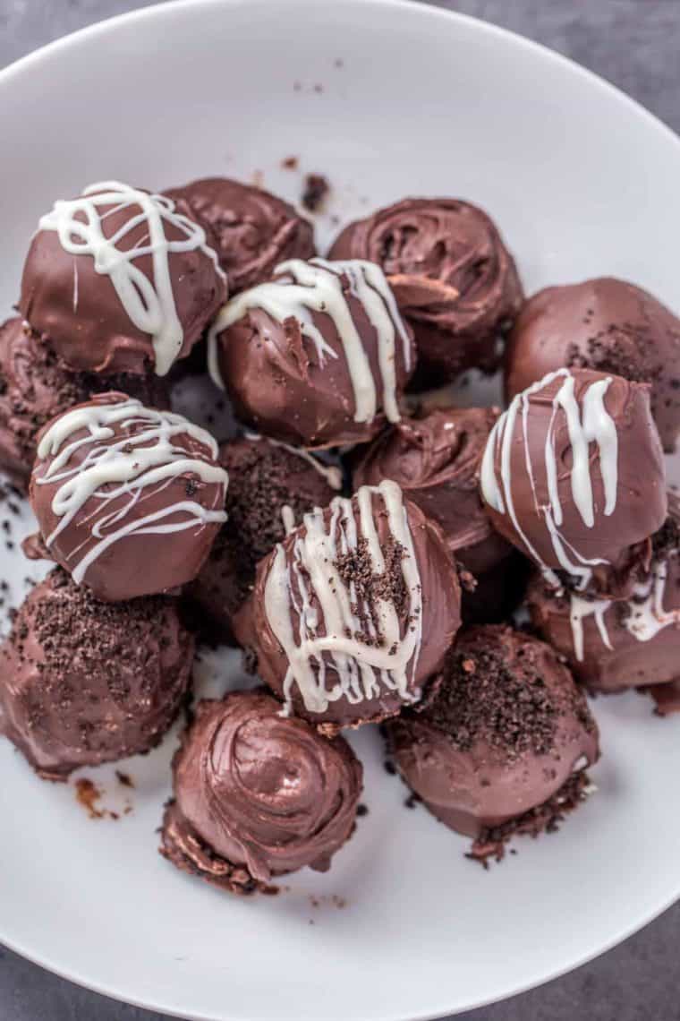 Oreo balls in a white bowl stacked on top of each other.