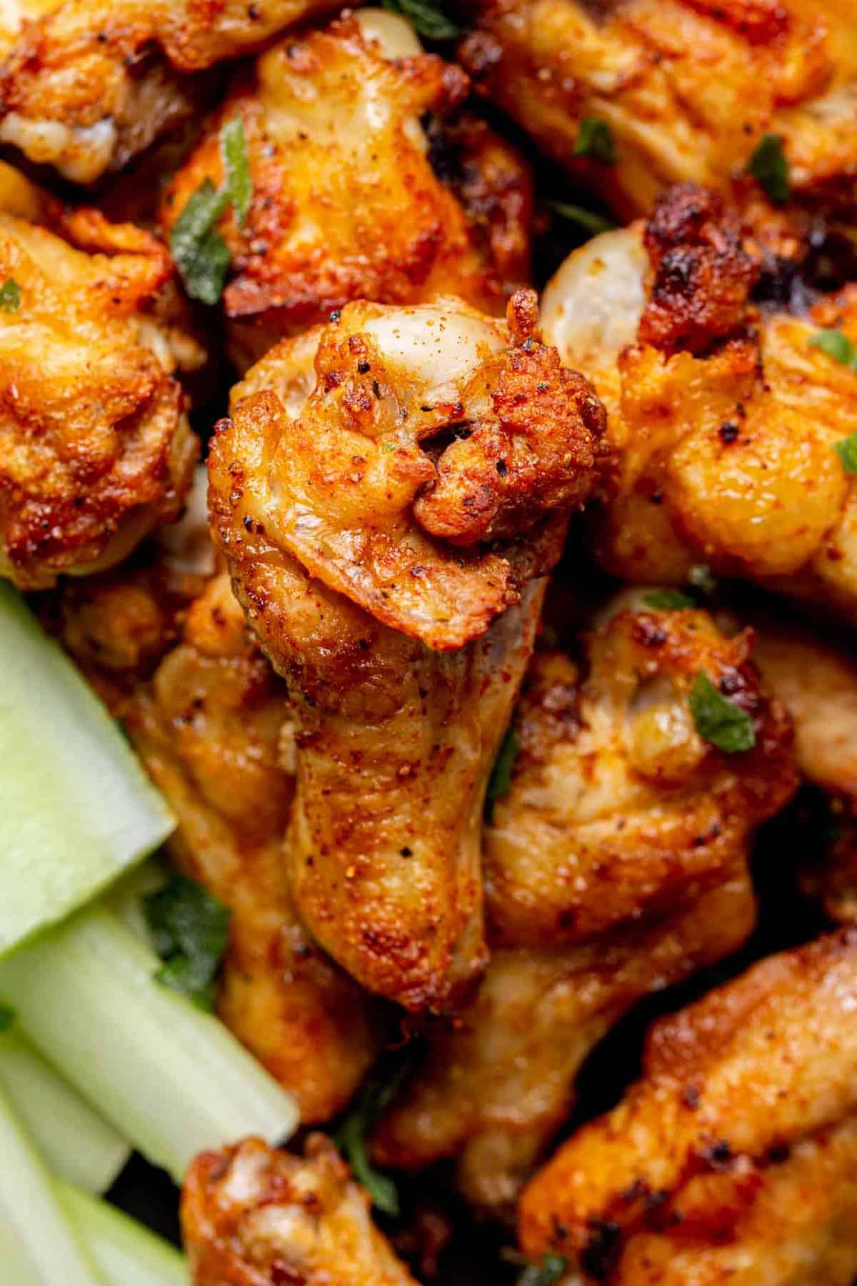 A pile of chicken wings with celery.