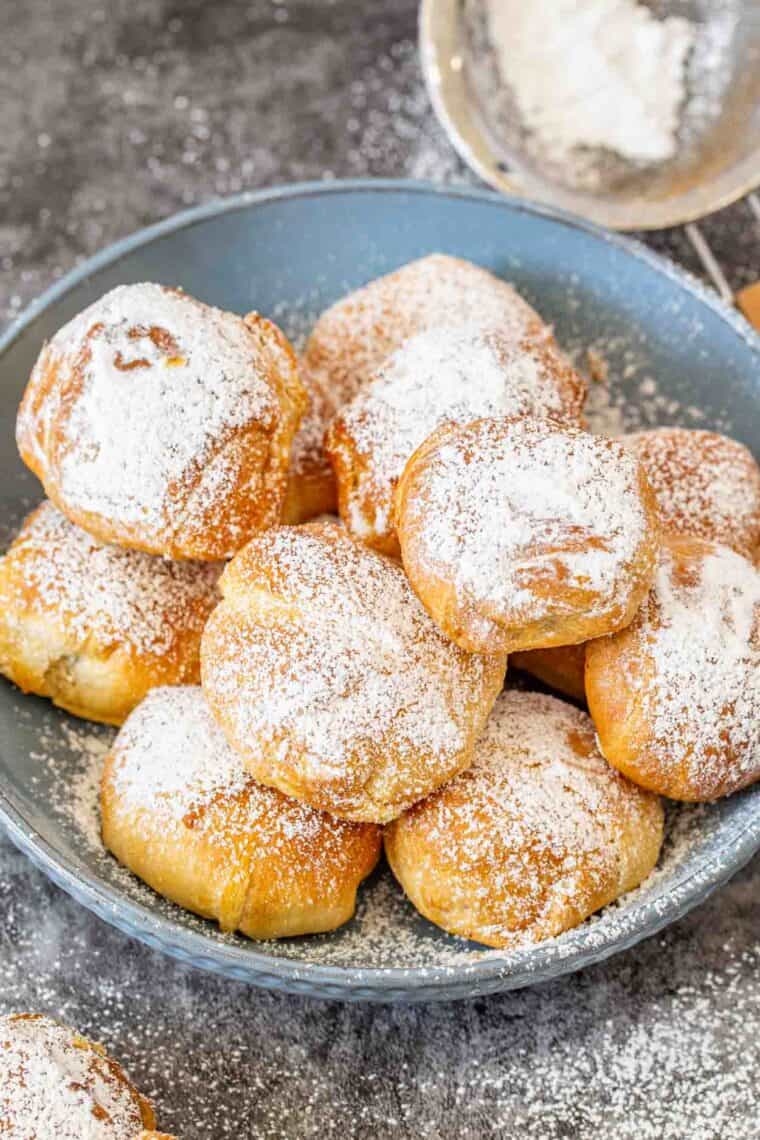 Crispy and delicious fried oreos in a bowl sprinkled with powdered sugar.