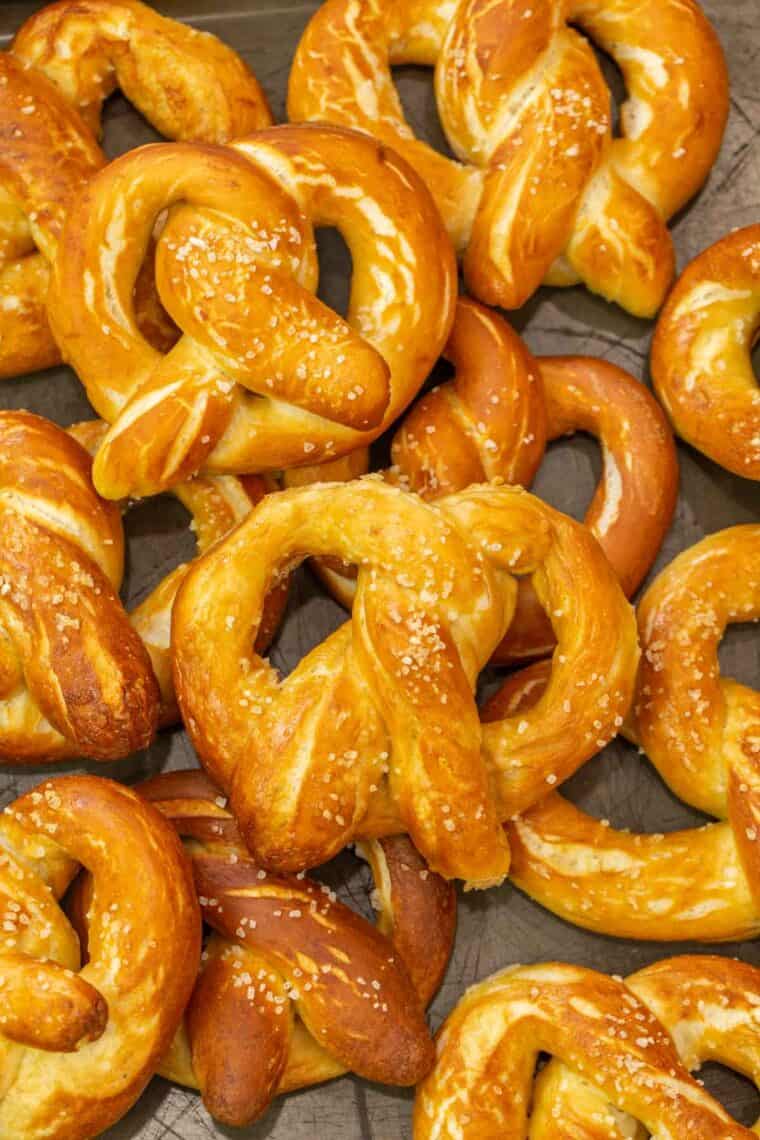 Soft and chewy homemade pretzels laid out on a baking sheet. 