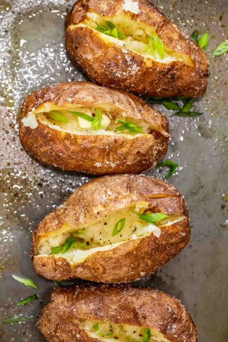 Baked Potatoes with toppings on a baking sheet. 