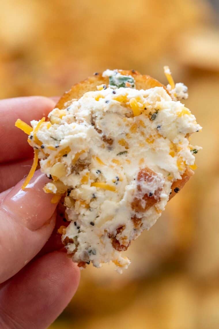 A cracker loaded with cream cheese cheese ball. 