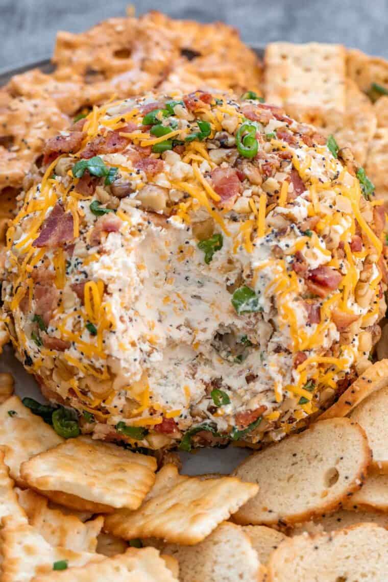 Cheeseball on a gray plate topped with fresh chopped greens. 