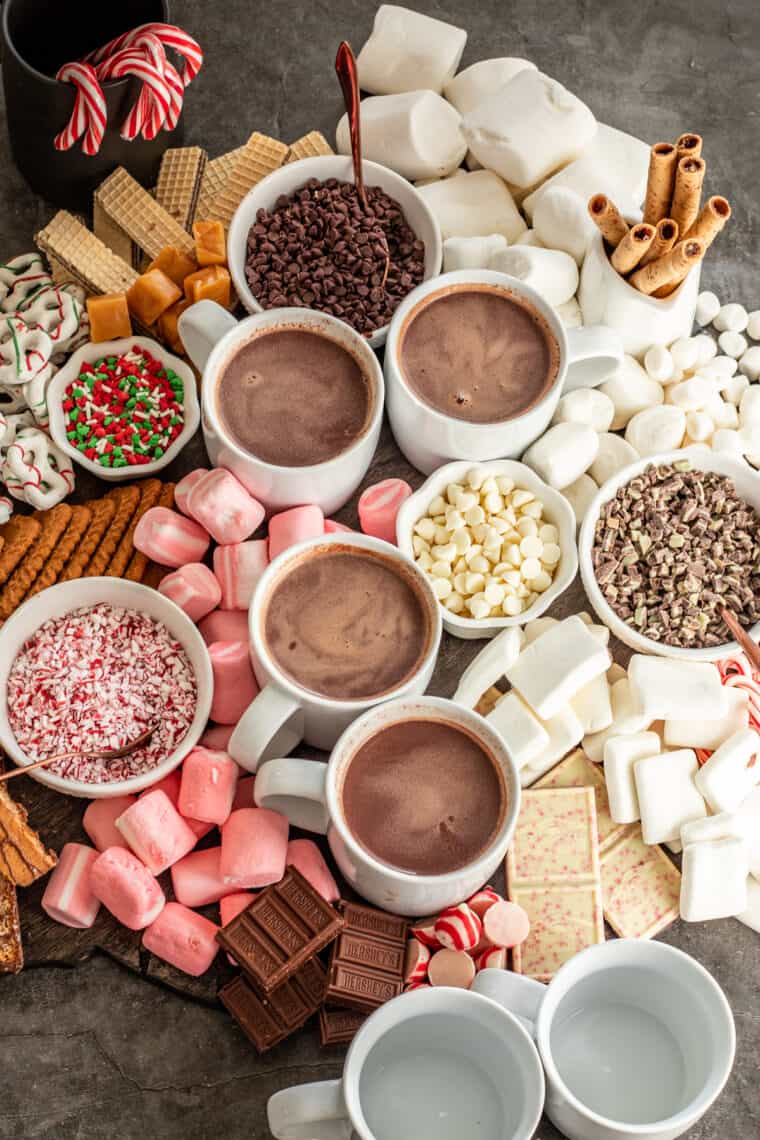 Four cups of crockpot hot cocoa on a hot chocolate charcuterie board.