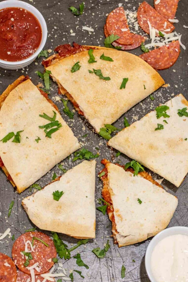 Crispy sliced air fryer quesadillas topped with parmesan cheese and chopped cilantro. 