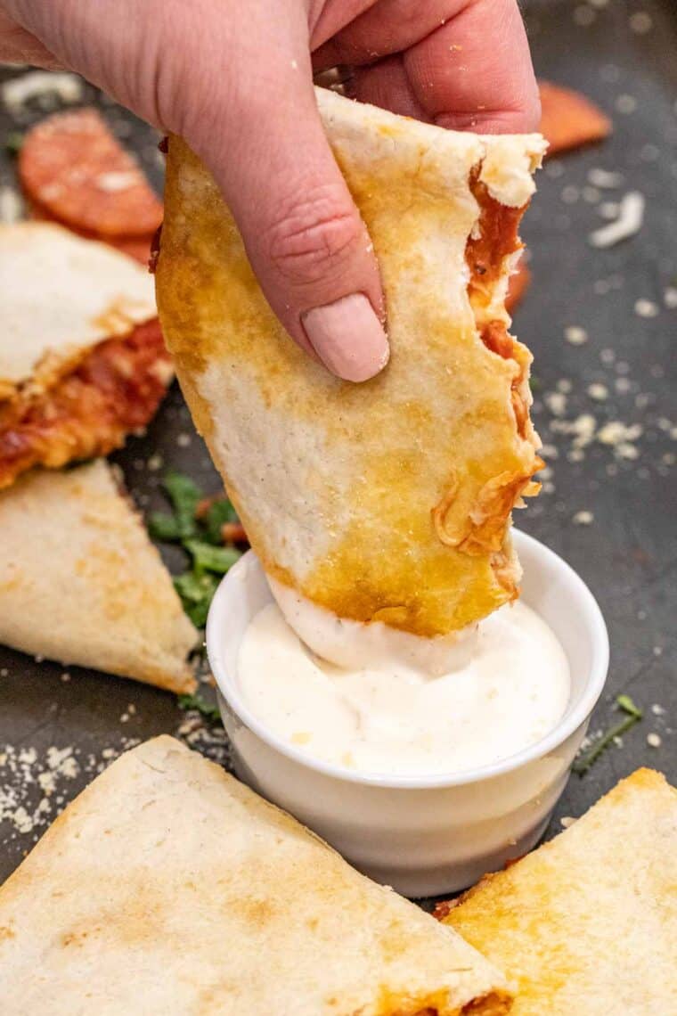 Air fryer quesadilla being dipped into Ranch. 