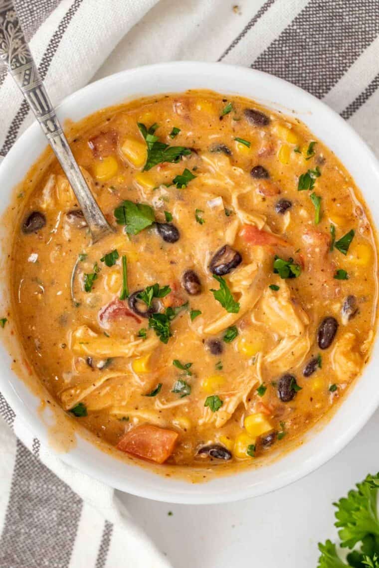 A bowl full of creamy enchilada soup with shredded chicken. 