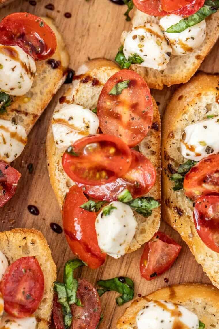 Crostini toast loaded with caprese salad drizzles in balsamic glaze. 