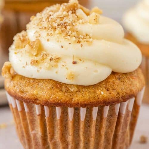 A beautifully frosted cupcake topped with chopped walnuts.