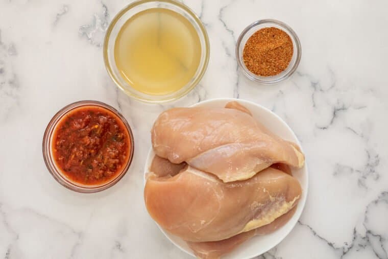 Four ingredients laid out for this easy shredded chicken recipe. 