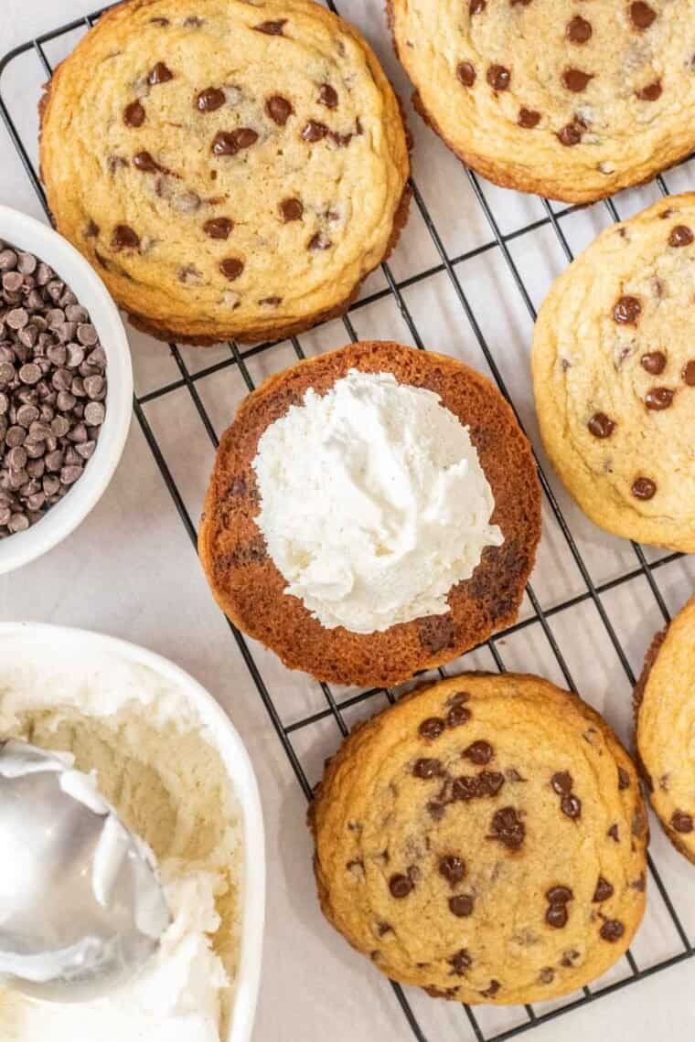Cookies laid out on a cooling rack with a scoop with vanilla ice cream. 