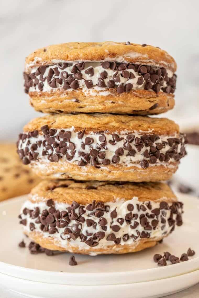 Three ice cream cookie sandwiches on a white plate. 