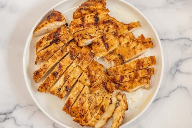 Sliced chicken breast on a white plate. 