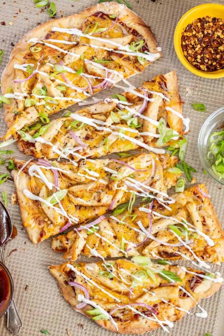 Flatbread pizza with bbq sauce, chicken, and shredded cheese and red onion. 