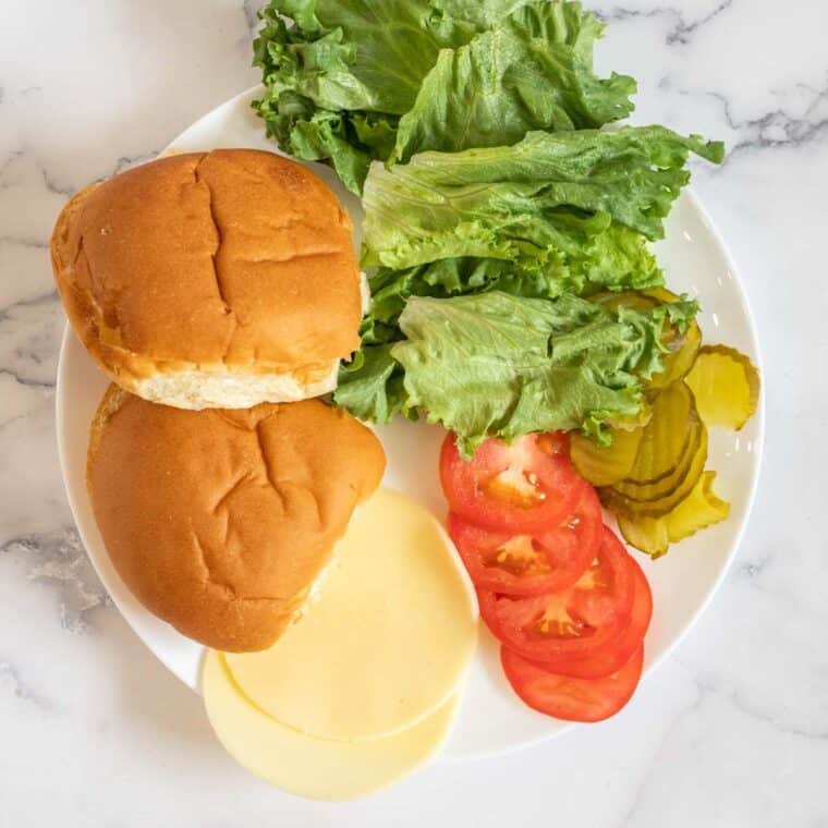 A white plate with all the ingredients for the spicy chicken sandwich. 