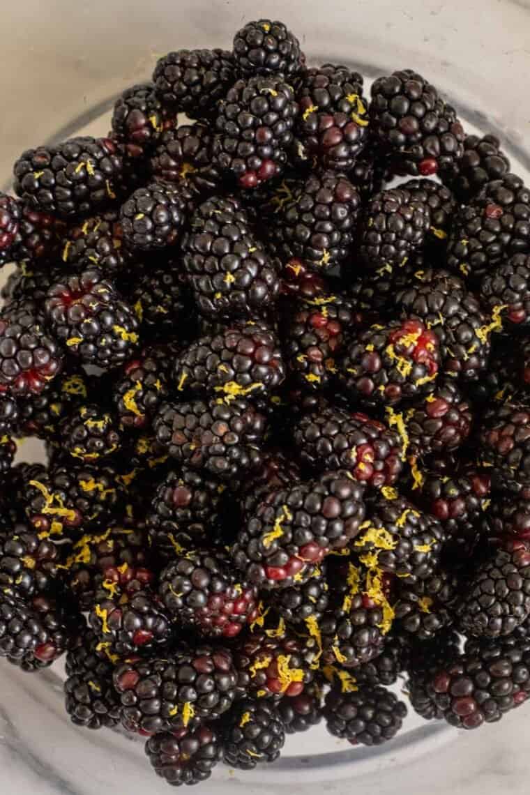 Fresh blackberries in a bowl topped with lemon zest. 