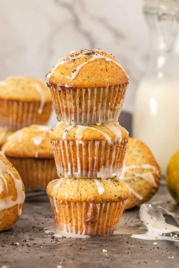 Three lemon poppy seed muffins stacked on top of each other. 