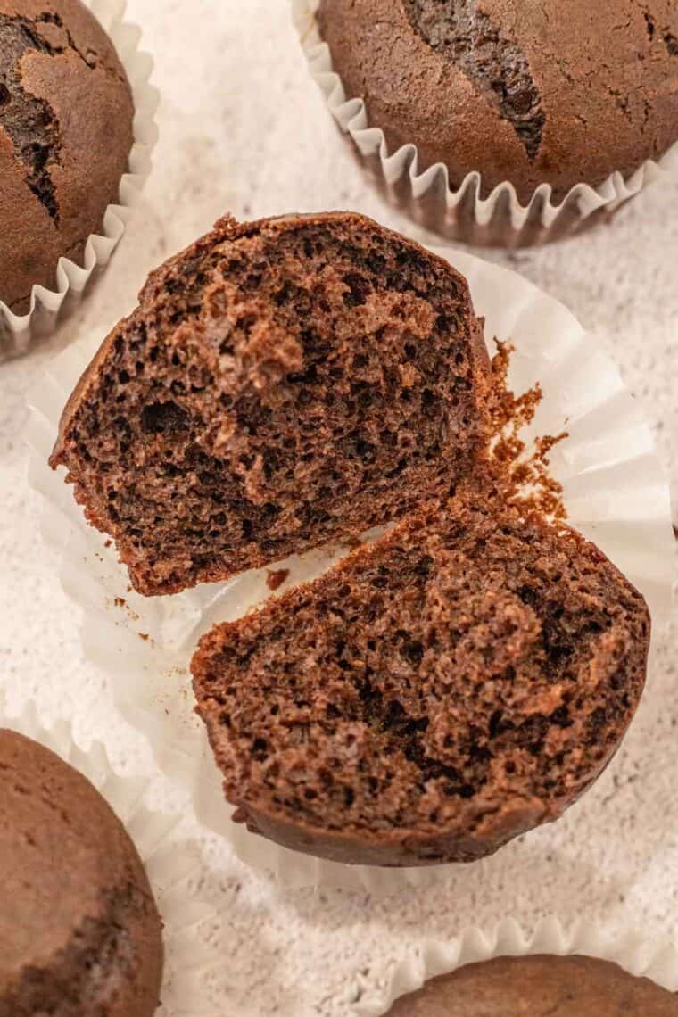 Moist chocolate cupcakes cut in half on a cupcake liner. 