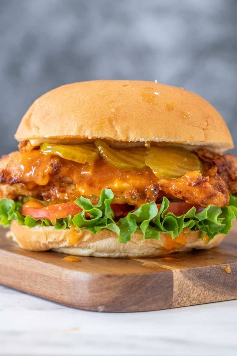 Spicy chicken sandwich on a cutting board. 