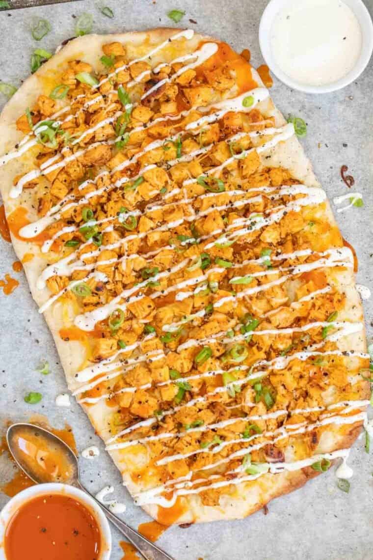 Buffalo Chicken Flatbread drizzled in ranch topped with greens.