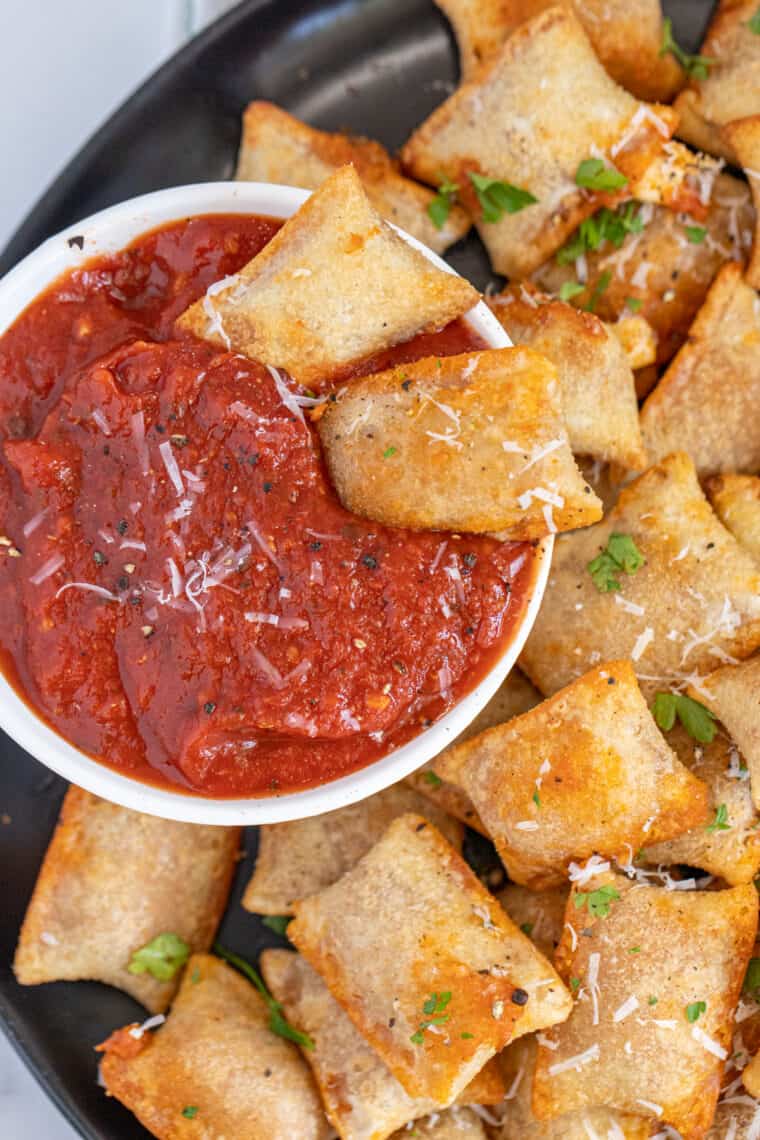 Two pizza rolls dipped in marinara sauce