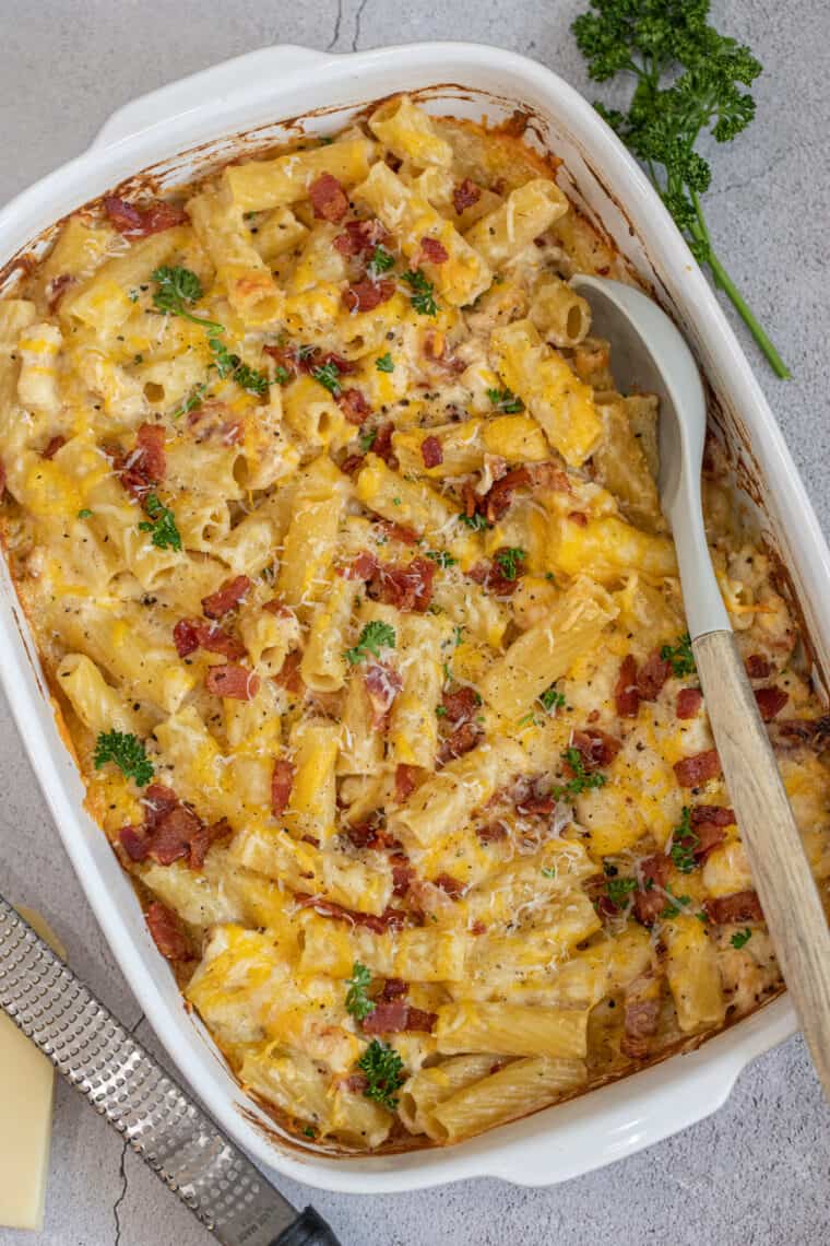 Pasta with bacon and chicken in an alfredo ranch sauce in a casserole dish. 