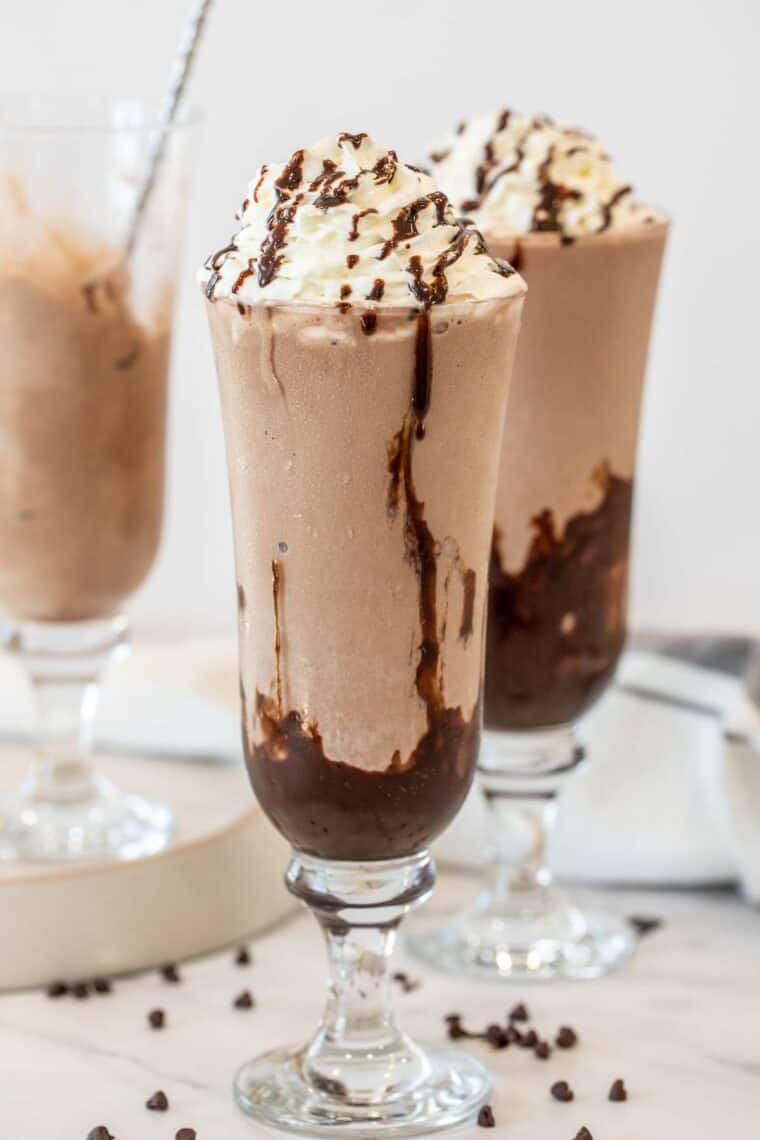 Choclate milkshake in glass cups with whipped cream. 