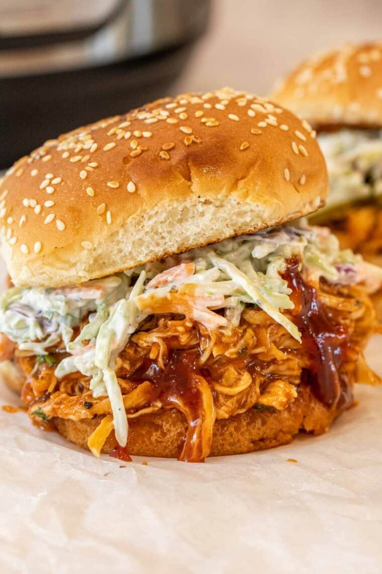 BBQ chicken breast inside of sandwich with closeslaw and buns.