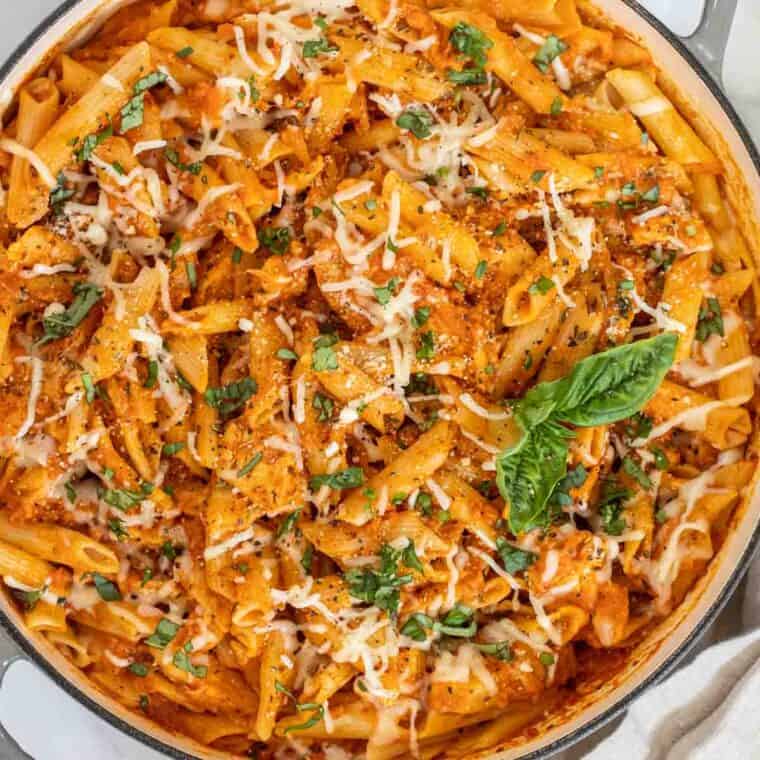 Parmesan chicken pasta in a skillet topped with cheese. 