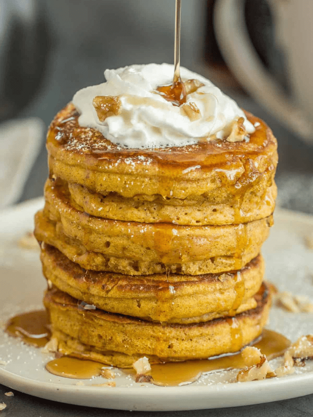A stack of pumpkin pancakes with a drizzle of maple syrup. 
