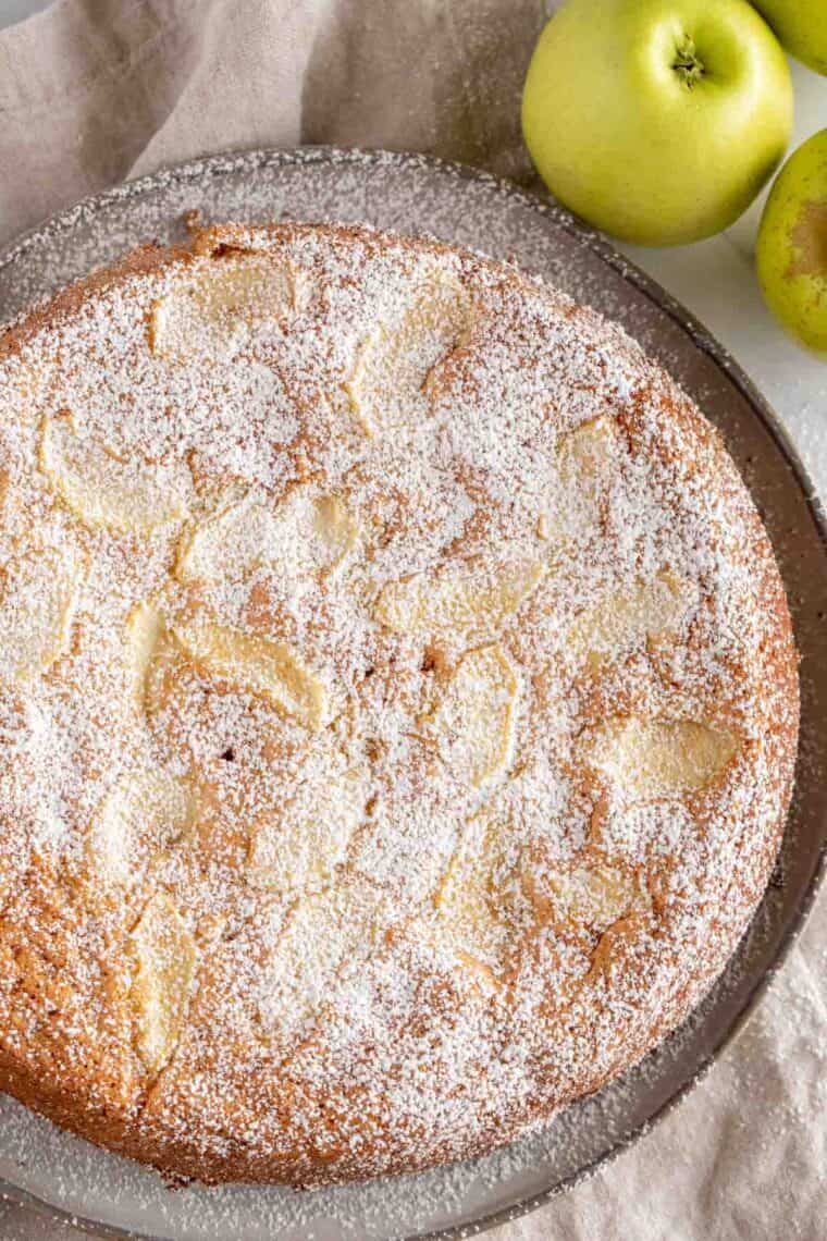 Close up of apple cake sprinkled with powdered sugar.