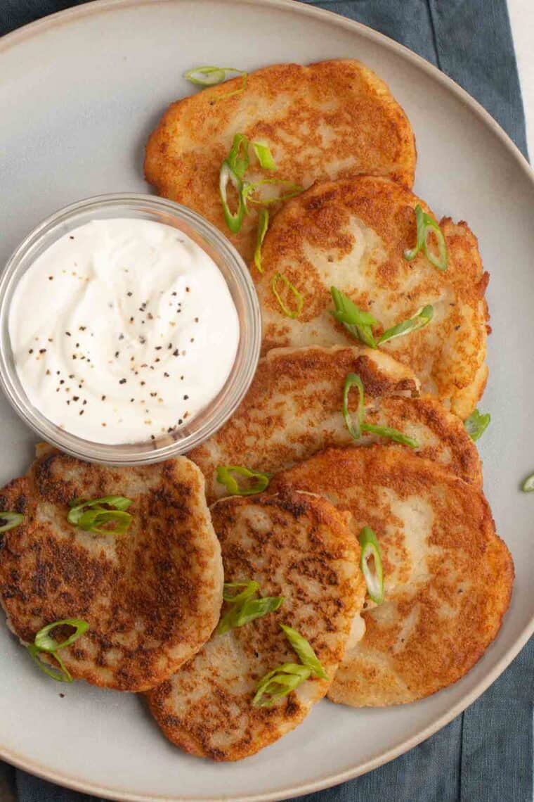 Potato pancakes with sour cream on a plate. 