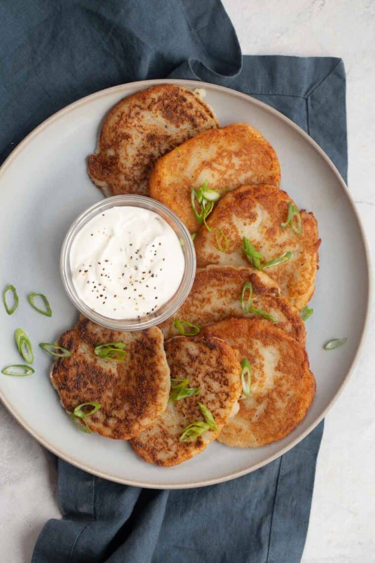 An easy potato pancake recipe on a plate with sour cream. 