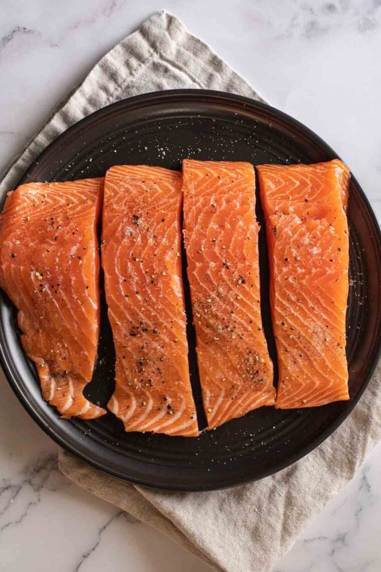 Close up of salmon on plate ready to be cooked.